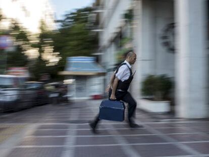 Un empleat de seguretat porta diners a una sucursal bancària a Atenes.