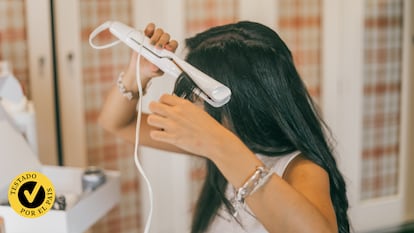 Una chica planchándose el cabello.