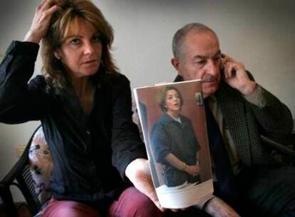 La hermana de María José Carrascosa, Victoria, junto a su padre, muestra la foto de la abogada detenida en Estados Unidos.