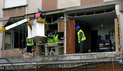 Varios operarios apuntalan el edificio cuya fachada se derrumbó sobre la terraza de una pizzería en Sueca.