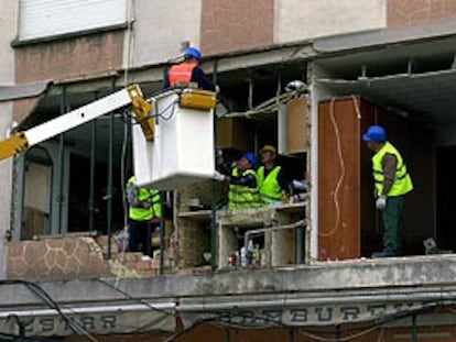 Varios operarios apuntalan el edificio cuya fachada se derrumbó sobre la terraza de una pizzería en Sueca.