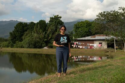 Corina Jiménez, líder comunitaria en la vereda la Cuesta, Ginebra, de 26 años, siempre anda descalza por el campo. Lo hacía de pequeña, cuando con una de sus mejores amigas, la hija de su vecina Luz Dary, correteaba alrededor de un estanque cercano a sus casas. En la imagen, posa junto a ese lugar. 