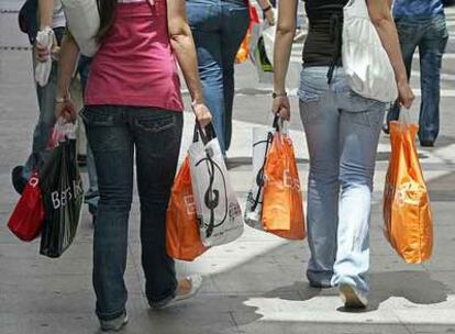 Varios clientes, a la salida ayer de una tienda situada en una zona comercial del centro de Madrid.