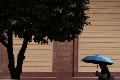 Una mujer se protege del sol con un paraguas este lunes en Sevilla.