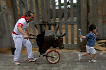 Un niño es perseguido por uno de los toros del 'encierro txiki' en Pamplona. 