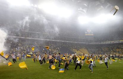 Aficionados del Fenerbahce invaden el campo y lanzan sillas a la policía turca.