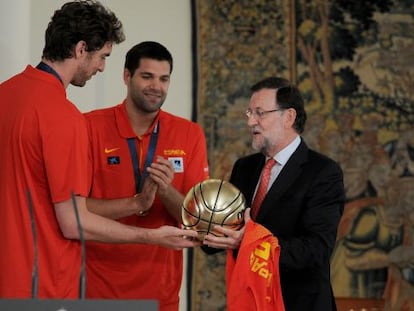 Gasol, a la izquierda, regala al presidente del Gobierno, Mariano Rajoy, un balón de plata en La Moncloa tras la victoria en el Eurobasket.