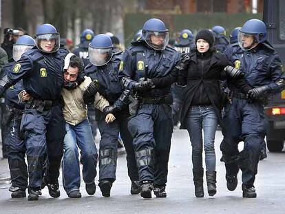La policía antidisturbios detiene a dos jóvenes tras los enfrentamientos de ayer en Copenhague.