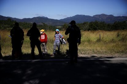 Policías hondureños retienen a migrantes en un retén en Ocotepeque, Honduras.