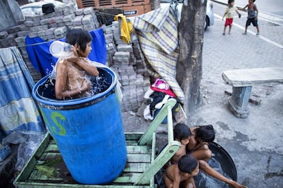 Niños se bañan en las calles de Manila (Filipinas). 