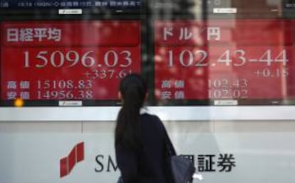 Una mujer observa unas pantallas de televisión que muestran información financiera de la Bolsa de Tokio. EFE/Archivo