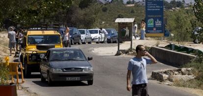 Ambiente de sábado en La Pedriza, con la barrera bajada y cola de coches para entrar, una vez superado el cupo.