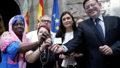El president de la Generalitat valenciana, Ximo Puig y la consejera de Sanidad, Carmen Montón, muestran una de las tarjetas sanitarias devueltas a inmigrantes.