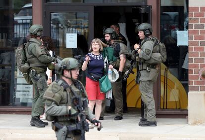 Las fuerzas de seguridad ayudan a evacuar a las personas de una tienda de Anthropologie en Highland Park, Illinois.