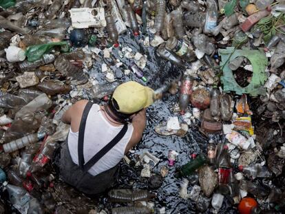 Un trabajador retira plásticos en la presa Mixcoac, en Ciudad de México.
