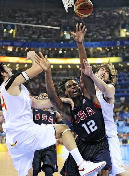 Alex Mumbrú y Marc Gasol luchan por un balón con Chris Bosh.