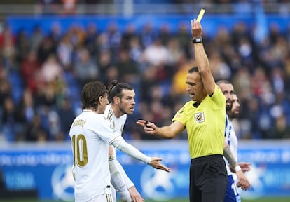 Bajo un monumental aguacero y ante un Alavés de lo más espinoso, Ramos y Carvajal sellaron el paso firme del Real en LaLiga. En la imagen, Cuadra Fernández, árbitro del encuentro, saca la tarjeta amarilla a Modric.