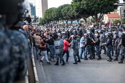 Policías antidisturbios y soldados libaneses se enfrentan a un centenar de jóvenes afines a los partidos de Amal y Hezbolá que llegaron en motocicletas para abrir por la fuerza los retenes de manifestantes que bloquean el centro de Beirut pidiendo la dimisión del Gobierno.