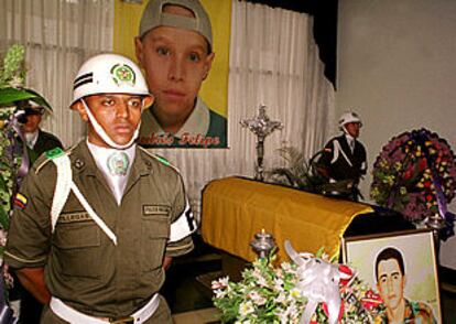 Una guardia de honor forma alrededor del ataúd de Norberto Pérez, situado bajo un retrato de su hijo.