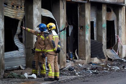 Los bomberos inspeccionan el exterior de la nave incendiada de Badalona.