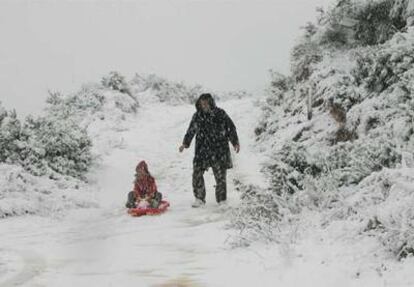 Un hombre juega en la nieve con su hijo cerca de Valencia.