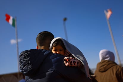 Un padre migrante con su hijo en brazos en el paso fronterizo en Ciudad Juarez (Mexico), el 17 de enero. 