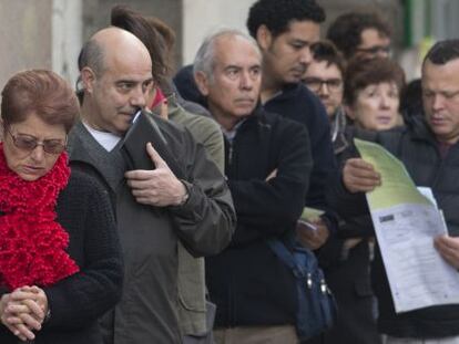 Jobseekers wait in line outside a Madrid unemployment office.