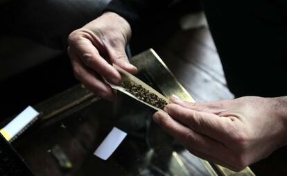 Un hombre l&iacute;a un cigarrillo de cannabis. 