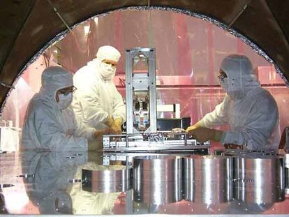 Tres expertos realizan ajustes en el detector de ondas gravitacionales LIGO en EE UU.