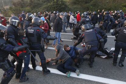 Agentes de los Mossos retiran a activistas independentistas de la autopista C-58, a la altura de Terrassa.