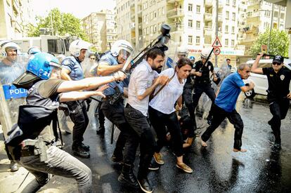 Un manifestante intenta proteger a la diputada Feleknas Uca, del Partido de la Democracia Popular (HDP), durante los enfrentamientos con la policía antidisturbios turca en una protesta contra el reemplazo de alcaldes kurdos por funcionarios estatales en tres ciudades, este martes en Diyarbakir. Los alcaldes de las provincias de Diyarbakir, Mardin y Van en el este de Turquía, todos miembros del Partido Democrático de los Pueblos Kurdos (HDP) elegidos en marzo, fueron suspendidos por supuestos vínculos con el proscrito Partido de los Trabajadores del Kurdistán (PKK).