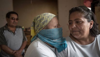 Víctor preparado para salir a la calle en tiempos de coronavirus, posa con sus padres en el salón de su casa.