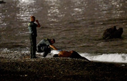 Miembros de la Guardia Civil atendían el viernes a un migrante llegado a nado en la frontera del Tarajal, en Ceuta.