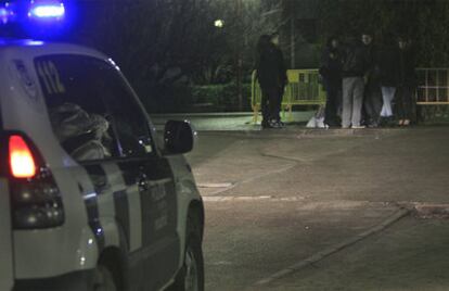 Un coche de la policía se acerca a un grupo de jóvenes que bebe anoche en el campus de la universidad.