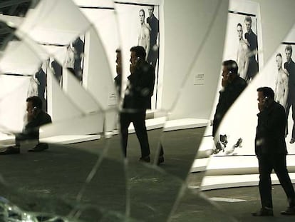 Un visitante se refleja en<i> Mirror Wall</i>, de Banks Violette, mientras pasa delante de la foto de Avedon <i>Andy Warhol and Members of the Factory</i>.
reuters