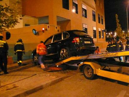 Empleados de la grúa municipal trasladan un Porsche Cayenne que guardaba el fallecido en el garaje.