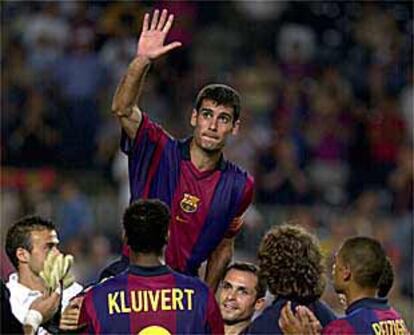 Guardiola, levantado a hombros por sus compañeros, saluda al público del Camp Nou.