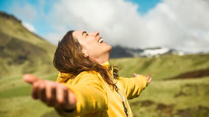 Una mujer siendo feliz en plena naturaleza.