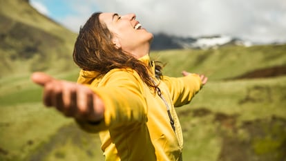 Una mujer celebra la contemplación de un paisaje.