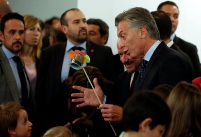 El presidente argentino Mauricio Macri recibe un de regalo de un niño durante su visita a la Feria Internacional de Arte Contemporáneo ARCO en Madrid.