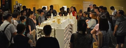 Un grupo de visitantes de la exposición de Seúl atienden a las explicaciones de una monitora delante de la maqueta general del edificio de La Pedrera.