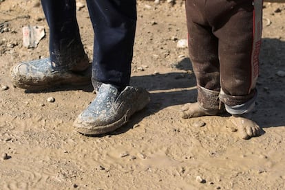 Niños desplazados caminan en el barro hacia los campamentos de refugiados, después de huir durante la ofensiva en curso de las fuerzas gubernamentales para volver a tomar la ciudad, en Mosul, Irak.