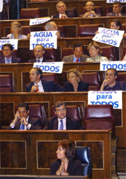 Diputados del PP muestran pancartas en las que se lee "Agua para todos".