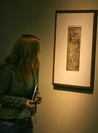 Una visitante observa <i>Tête de femme,</i> un grabado de González basado en un dibujo de Picasso.