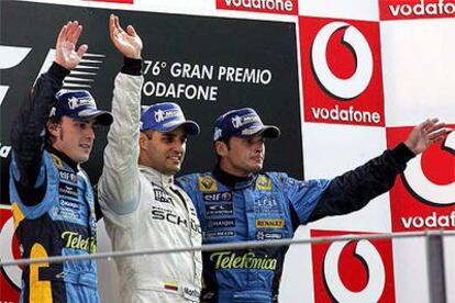 Fernando Alonso, a la izquierda; Juan Pablo Montoya, en el centro, y Giancarlo Fisichella, saludan desde el podio ayer en Monza.