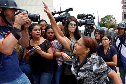 Una partidaria del presidente venezolano, Nicolás Maduro, intenta retirar la cámara de un fotógrafo durante enfrentamientos con partidarios de la oposición fuera del Tribunal Supremo de Justicia.