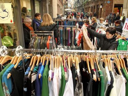 Una mujer observa las ofertas de uno de los puestos del mercado de gangas del Casco Viejo de Bilbao.