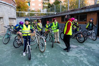 Los niños que participan del bicibús del colegio Jesús Maestro preparan sus bicicletas y elementos de seguridad en el patio escolar. 