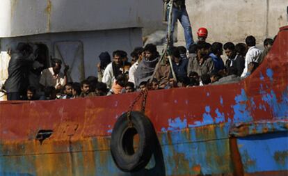 Un grupo de inmigrantes supuestamente paquistaníes, a bordo de la embarcación, tras llegar al puerto de Sante Cruz de Tenerife esta mañana.