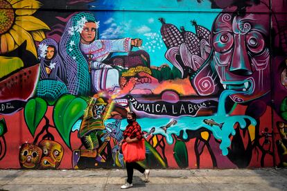 Una mujer camina al lado del mercado de Jamaica en Ciudad de México.